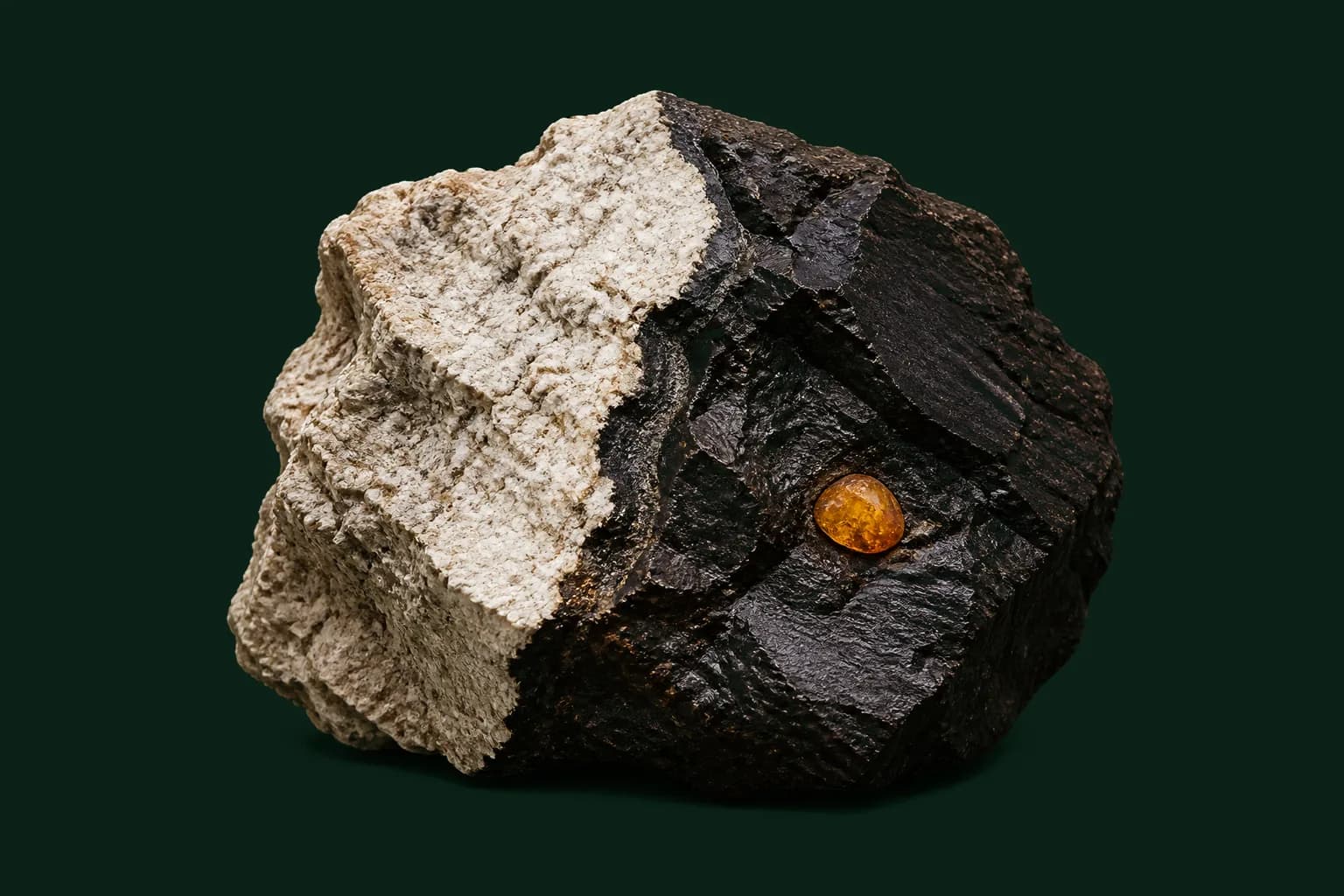 Duża kanciasta bryła leonardytu o surowym przełamie kopalnianym i mineralnej skorupie z jednej strony